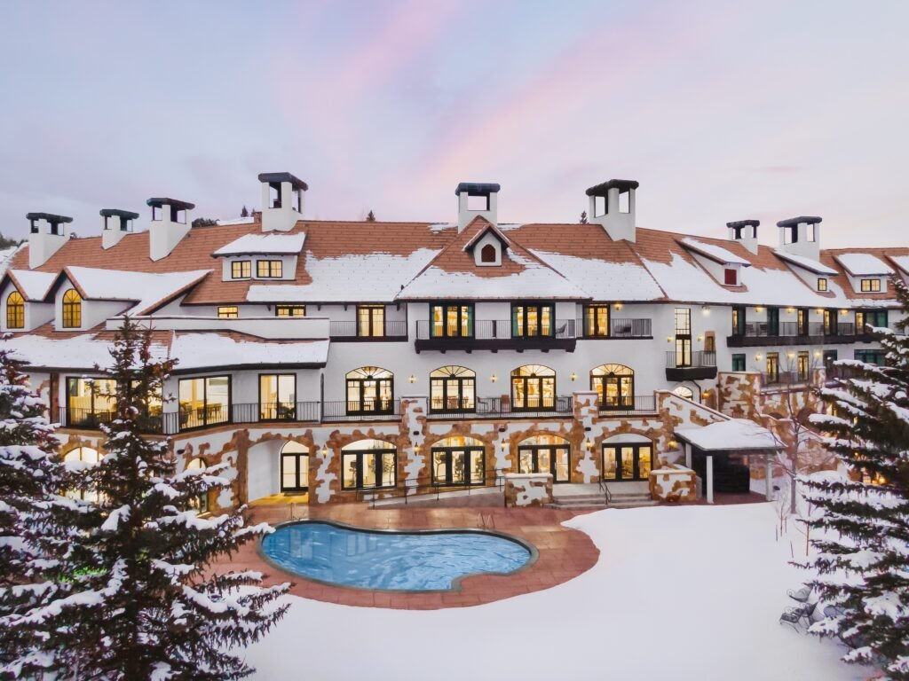 Elegant commercial building with snow-covered roof, large windows, and a central pool area. Click to order a Commercial Architectural Photography Package for stunning property showcases.