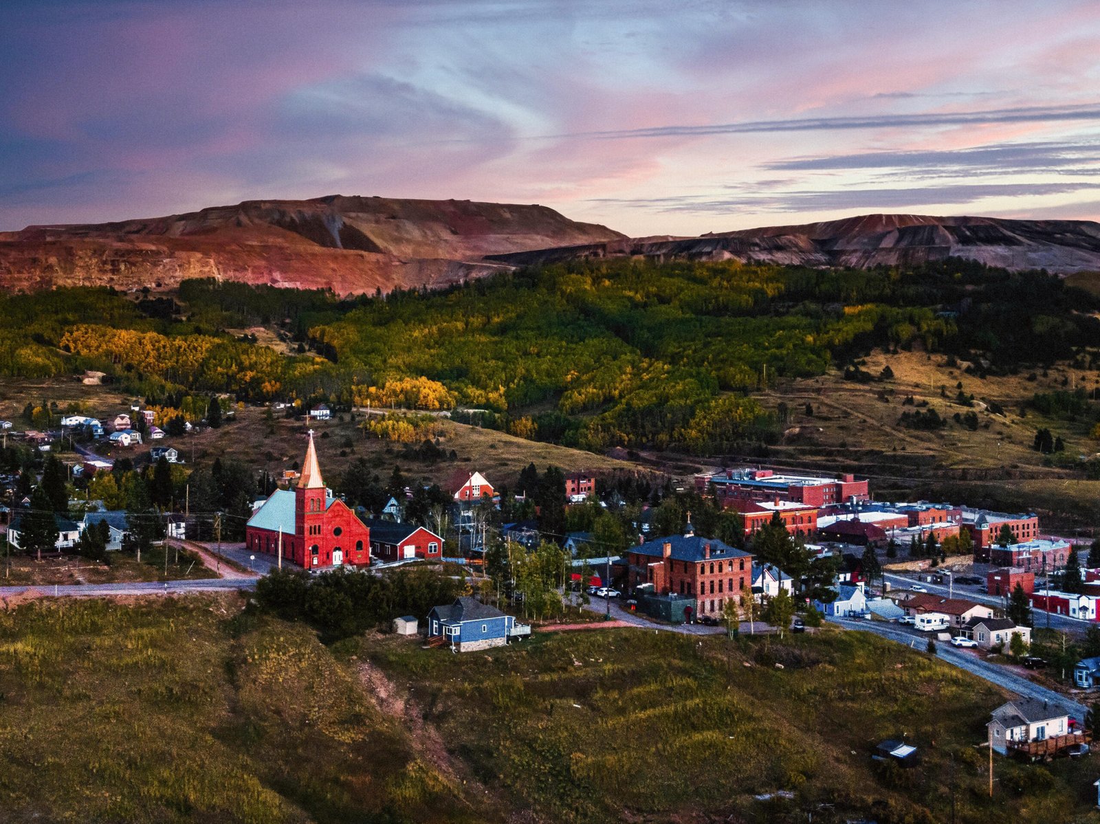 Aerial view of Hotel St. Nicholas in Cripple Creek at twilight, showcasing its historic charm, glowing lights, and dramatic mountain backdrop—perfect for luxury hospitality and Denver drone photography enthusiasts.